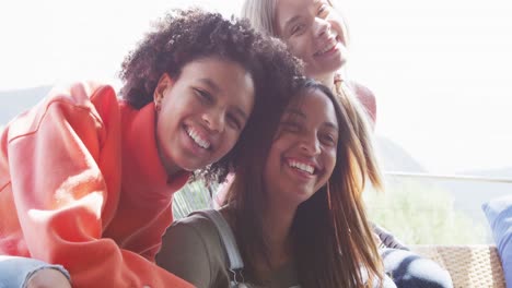 portrait of happy diverse teenager girls friends embracing at home, slow motion