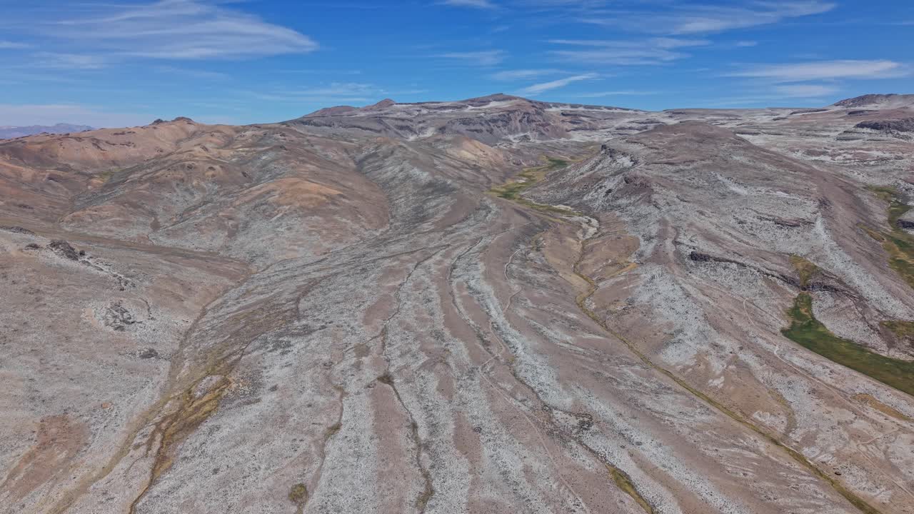 Una ripresa aerea inversa rivela scie di lava rosse, gialle e verdi coperte di sale, che mostrano l’inconfondibile terreno vulcanico minerale del Perù.