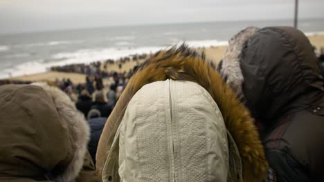 people standing on a windy beach at westerland, sylt, germany