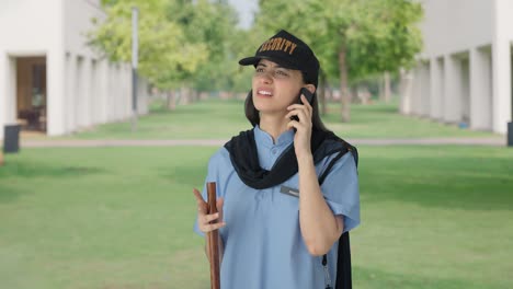confused indian female security guard talking to someone on call