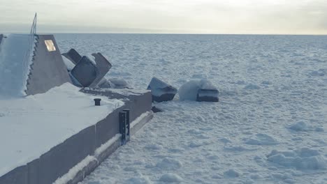 aerial along breakwater surrounded by frozen drift sea ice in hokkaido