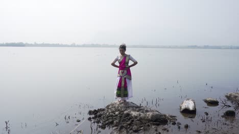 a bharatnatyam dancer displaying a classical bharatnatyam pose in the nature of vadatalav lake, pavagadh