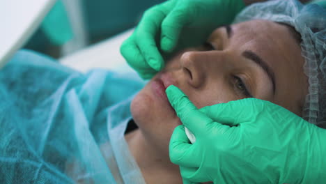 la señora habla con el cosmetólogo en el procedimiento de aumento de labios
