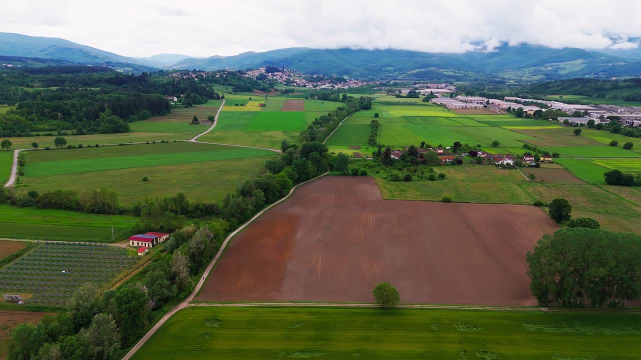 Panning right aerial drone shot of Tuscany's countryside and farmlands in Bibbiena, Italy (Toscana), showcasing scenic rural landscapes