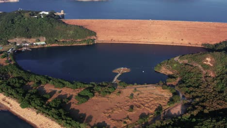 aerial view of a beautiful reservoir created by the dam and a small village on the bank of the reservoir in hong kong geographical park in sai kung on a sunny day