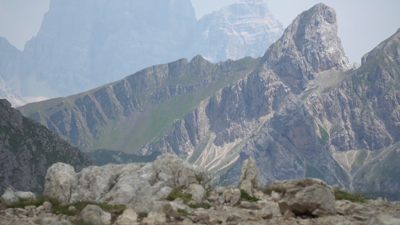 el excursionista se para en las rocas y observa el hermoso panorama de los dolomitas