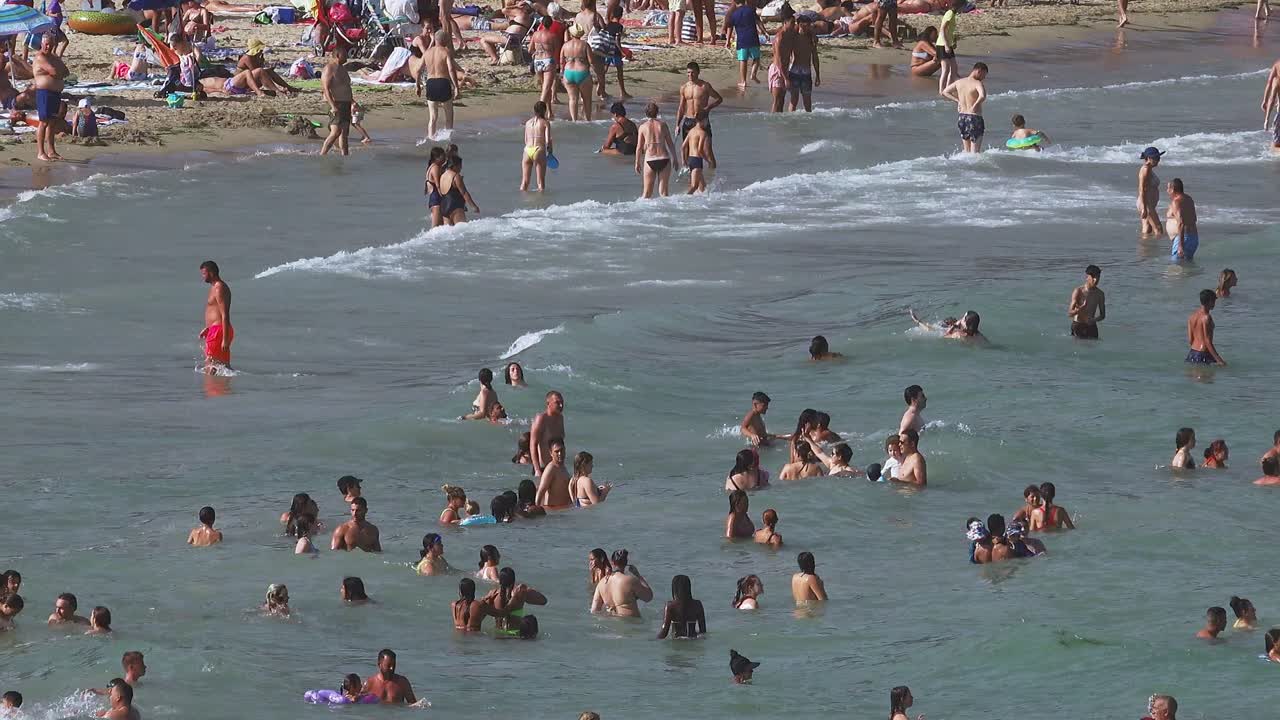 Crowds of tourists flock to the beach to escape the sweltering heatwave Alicanti