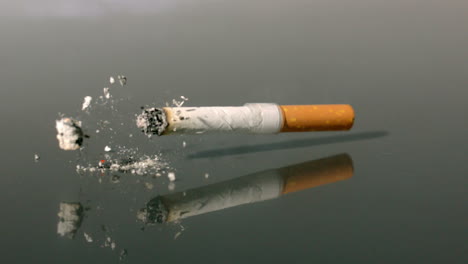 Cigarette-falling-onto-reflective-surface