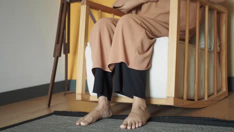 person sitting in a wooden rocking chair