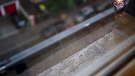 raindrops on window with blurred street scene below, reflective mood, overcast day