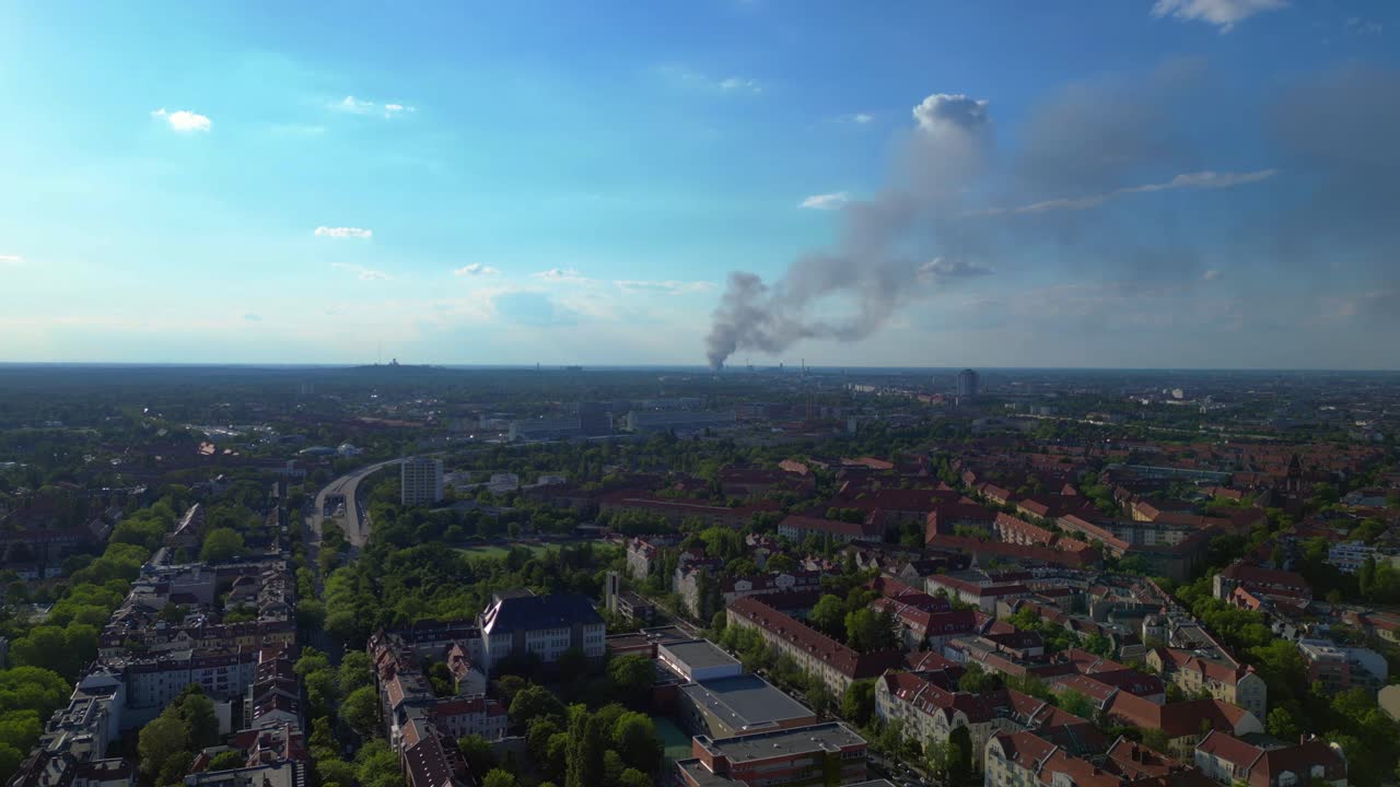 big black smoke rising over Berlin, Germany, on sunny day with blue sky and some clouds. Great aerial view flight panorama overview drone