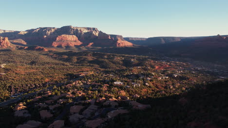 Sedona,-Arizona,-USA-Bei-Sonnenaufgang,-Luftaufnahme-Von-Häusern-Und-Wohnungen-Im-Tal-Unter-Malerischen-Roten-Felshügeln