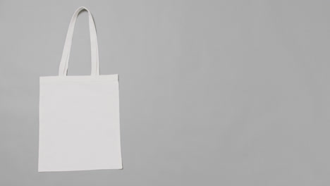 close up of white bag on grey background, with copy space, slow motion