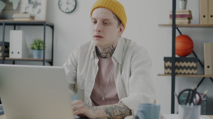 Ung person arbejder på bærbar computer på moderne hjemmekontor