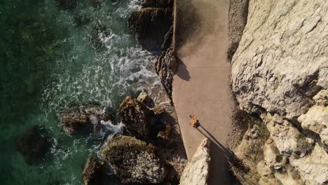 shot floating with drone over a woman who looks at the adriatic sea and is at peace admired by nature