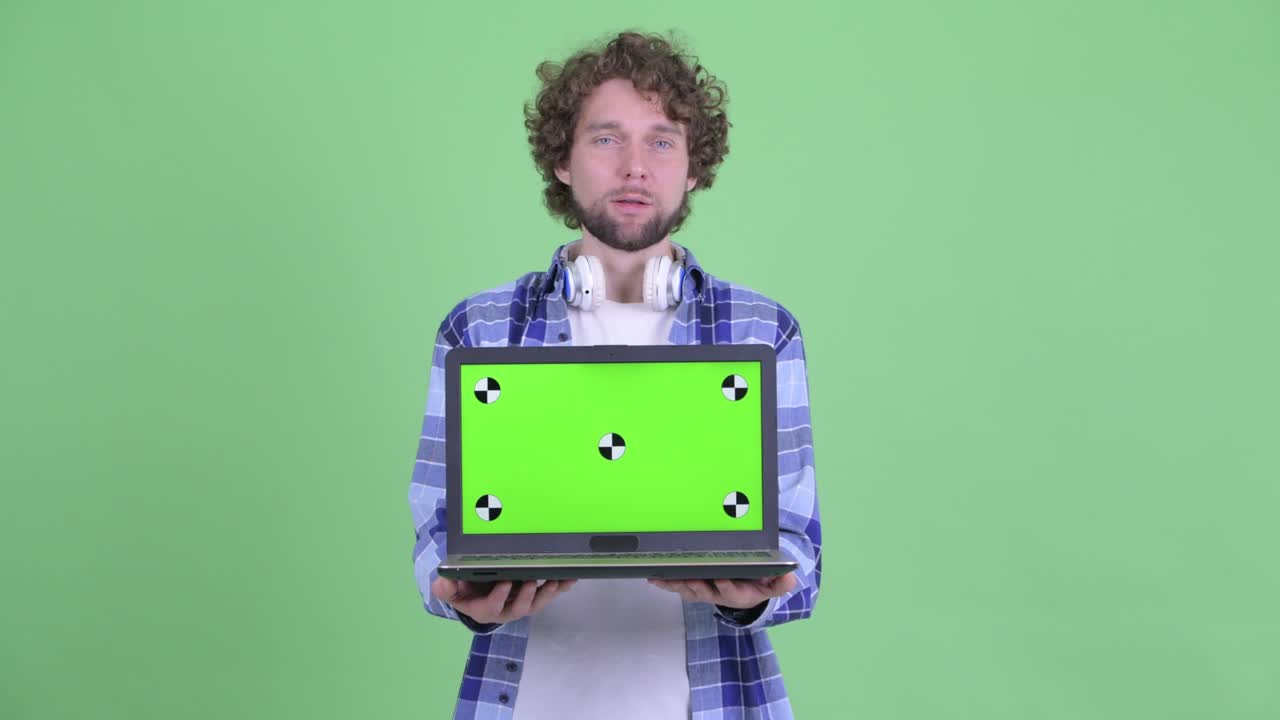 un joven guapo, barbudo y hipster con el cabello rizado.