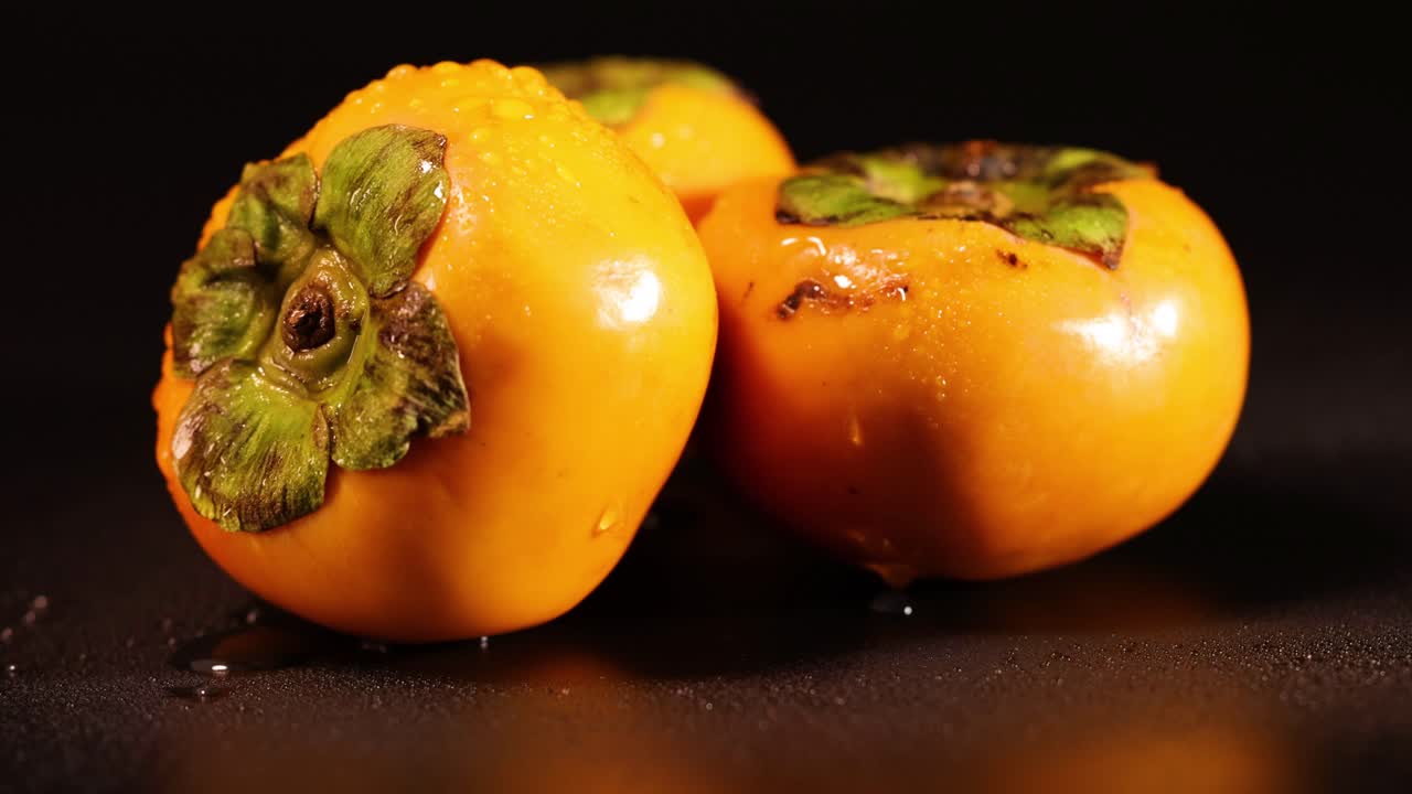 primer plano de persimones maduros con gotas de agua