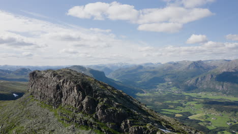 Breathtaking-aerial-orbit-shot-of-Storehorn-Peak,-revealing-Hemsedal-in-the-background-valley-below