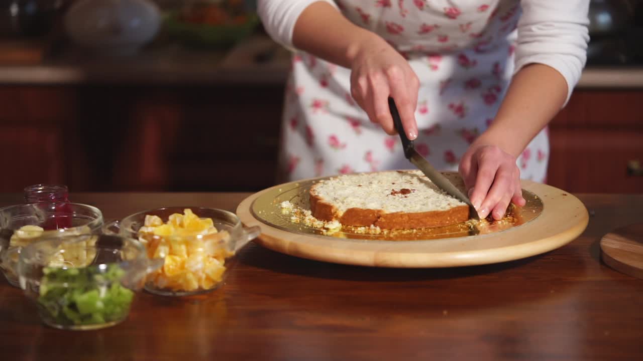 mujer cortando un pastel en capas en una cocina