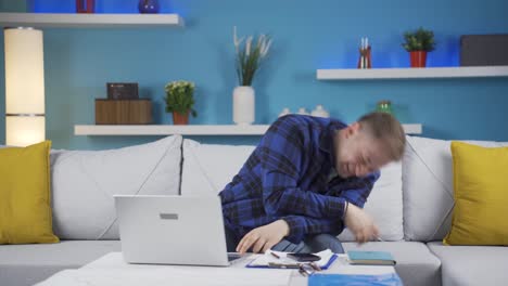trabajador de oficina en casa, hombre divertido trabajando en una computadora portátil, usándola.