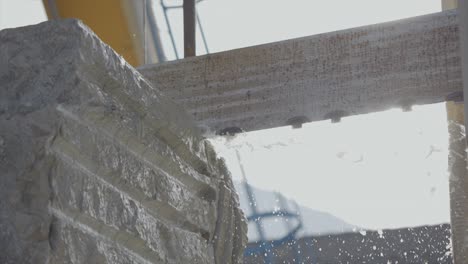 primer plano de una máquina de sierra cortando piedra de bloques de mármol