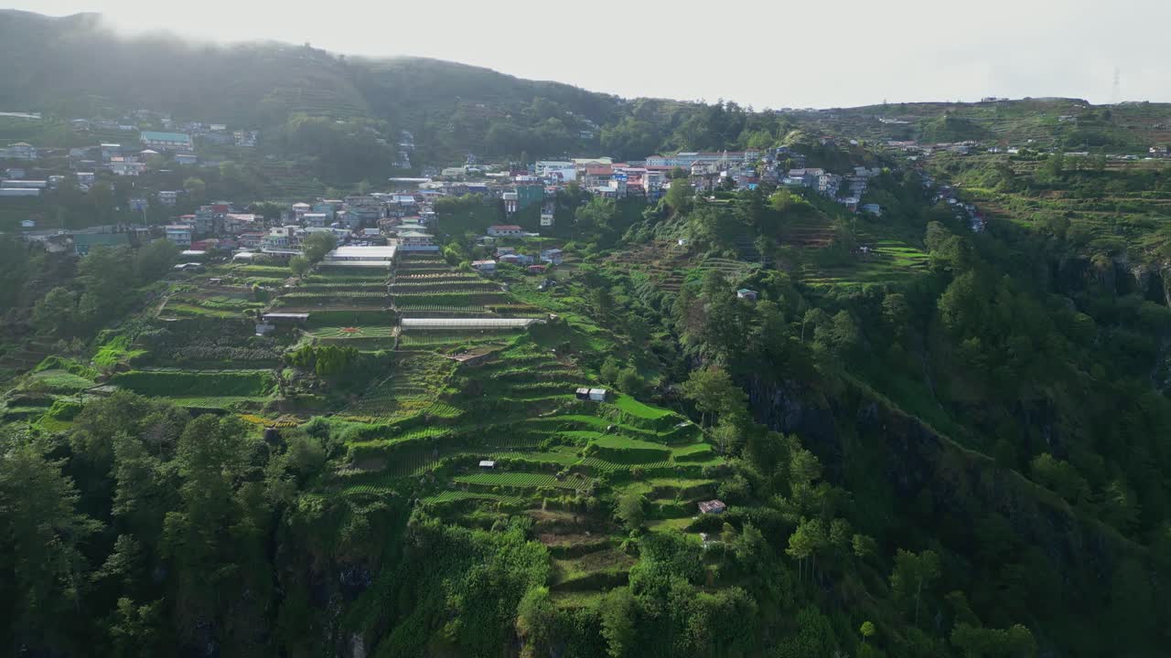 Atok, Benguet'in katmanlı pirinç tarlaları ve sisle kaplı dağ zirveleriyle çevrili yoğun şehir merkezine doğru yaklaşan yüksek ileri hava süzülüşü