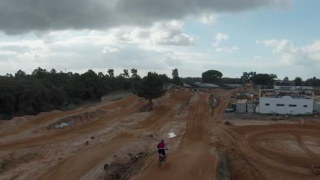 dirt motocross track with ramps and two riders riding on it