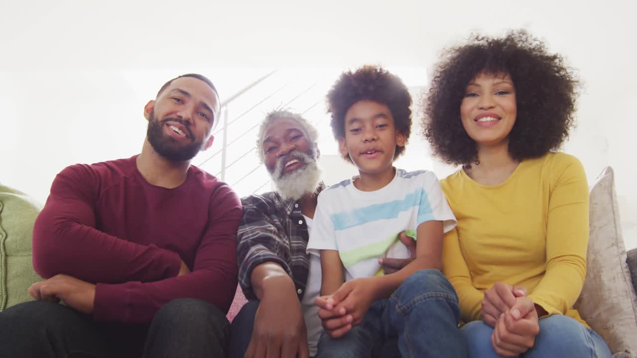 семья из нескольких поколений машет камере дома.