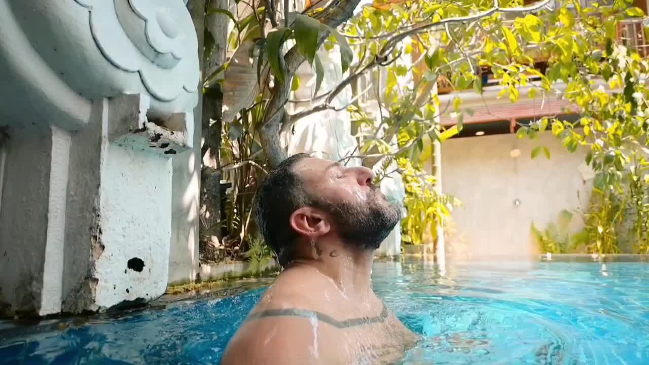 man coming out of pool water in slow motion