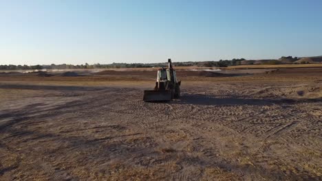 drone video of a backhoe tractor in the desert