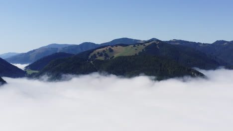 beautiful mountain peaks and valleys of liptov, slovakia, aerial pull back shot disappearing into the thick clouds