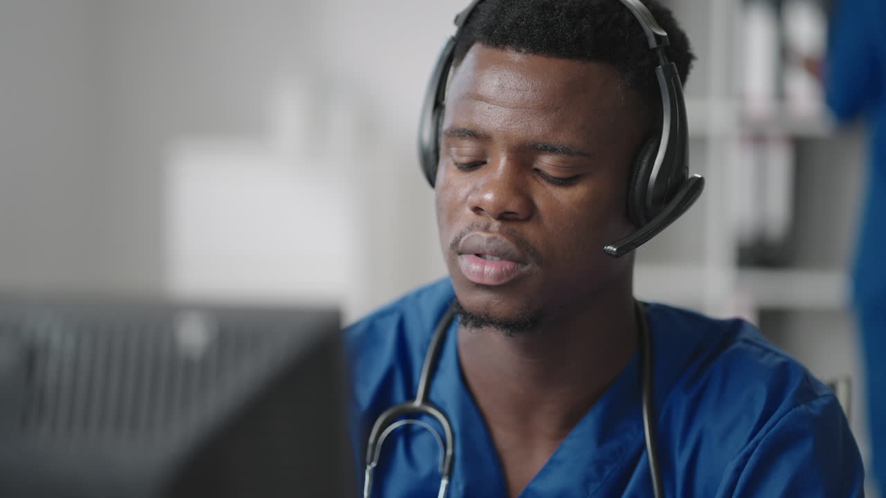 Consulto medico online: Medico afroamericano che effettua una videochiamata in conferenza con un paziente su un computer desktop.