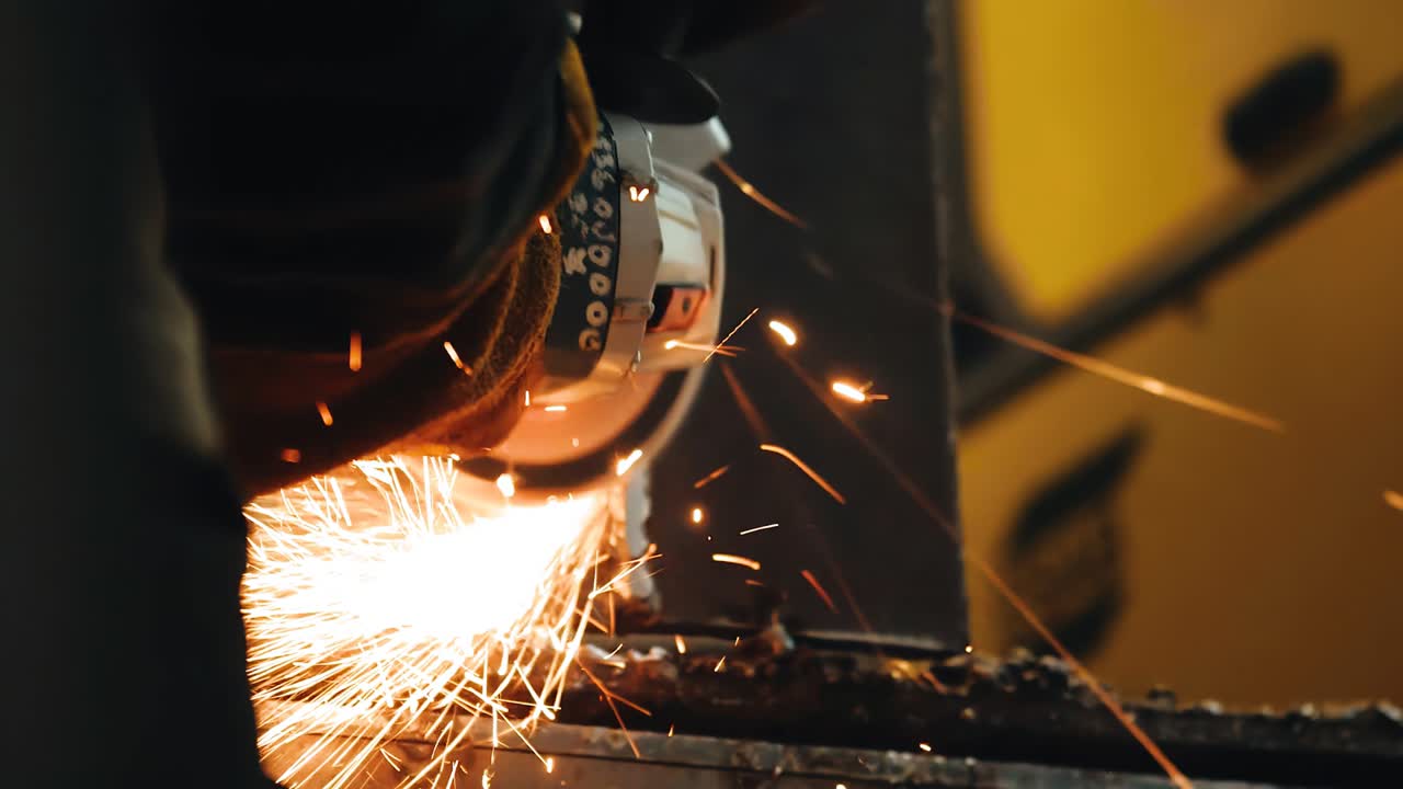 용접 접합을 청소하는 동안 금속에서 불꽃이 날아갑니다. 근접 촬영