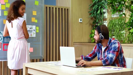 ejecutivos discutiendo entre sí mientras usan una computadora portátil