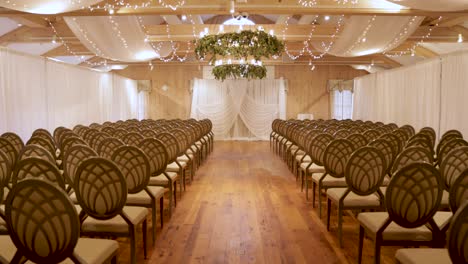 elegant luxurious indoor wedding ceremony set-up with lights and greenery