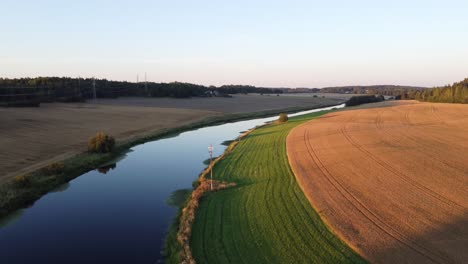 Pequeño-Río-Rodeado-De-Campos-Durante-La-Puesta-De-Sol