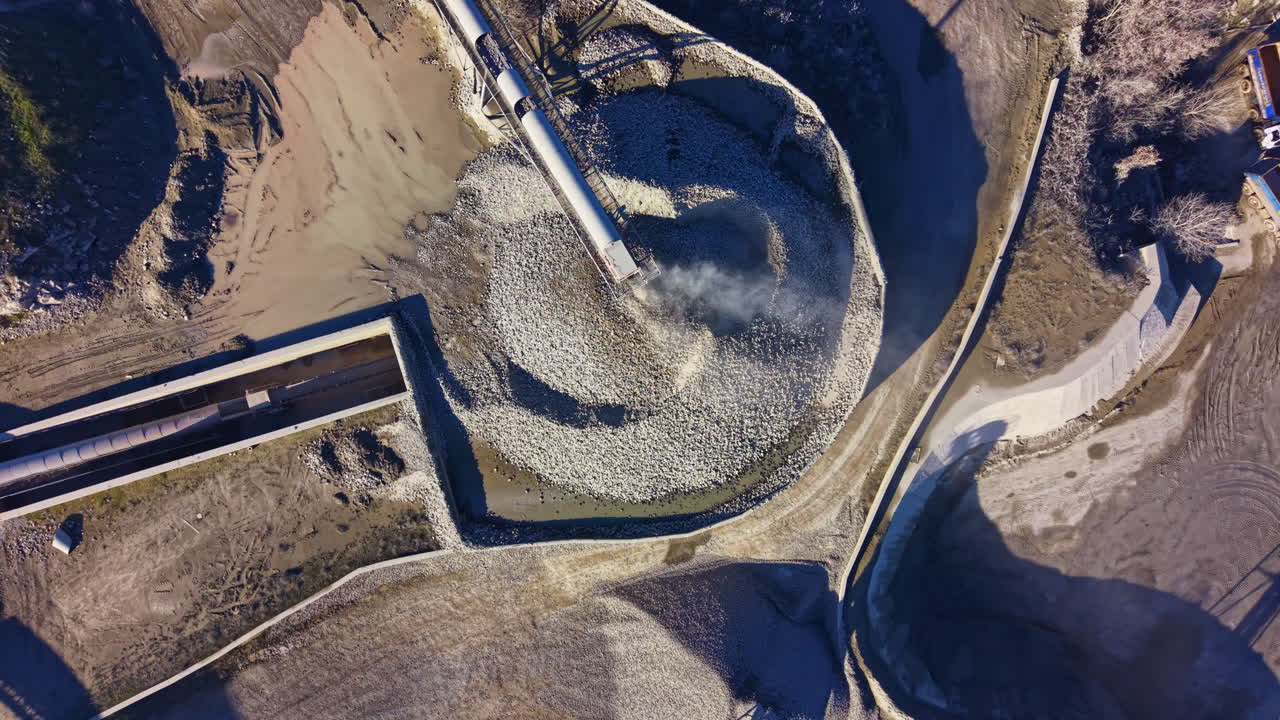 Swirling patterns of rock and water in a vast landscape under the bright midday sun showcase nature's intricate designs