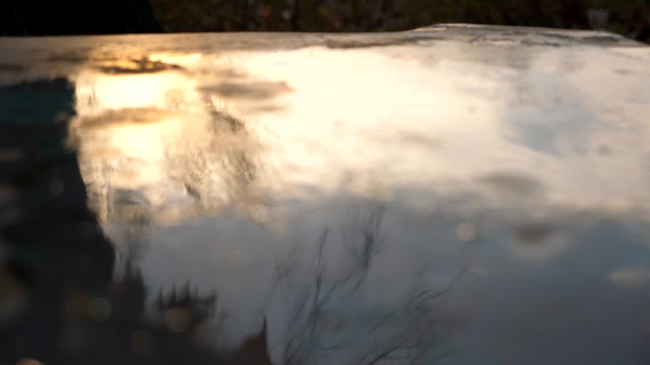 공원의 테이블 위에 웅이에 떨어지는 다채로운 잎자루의 근접. 은 메이플 잎은 비가 내린 후 책상의 은 표면에 놓여 있습니다. 가을 자연 계절. 낮은 각도 뷰 느린 동작