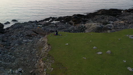 man sitting in solitude in rocky beach landscape