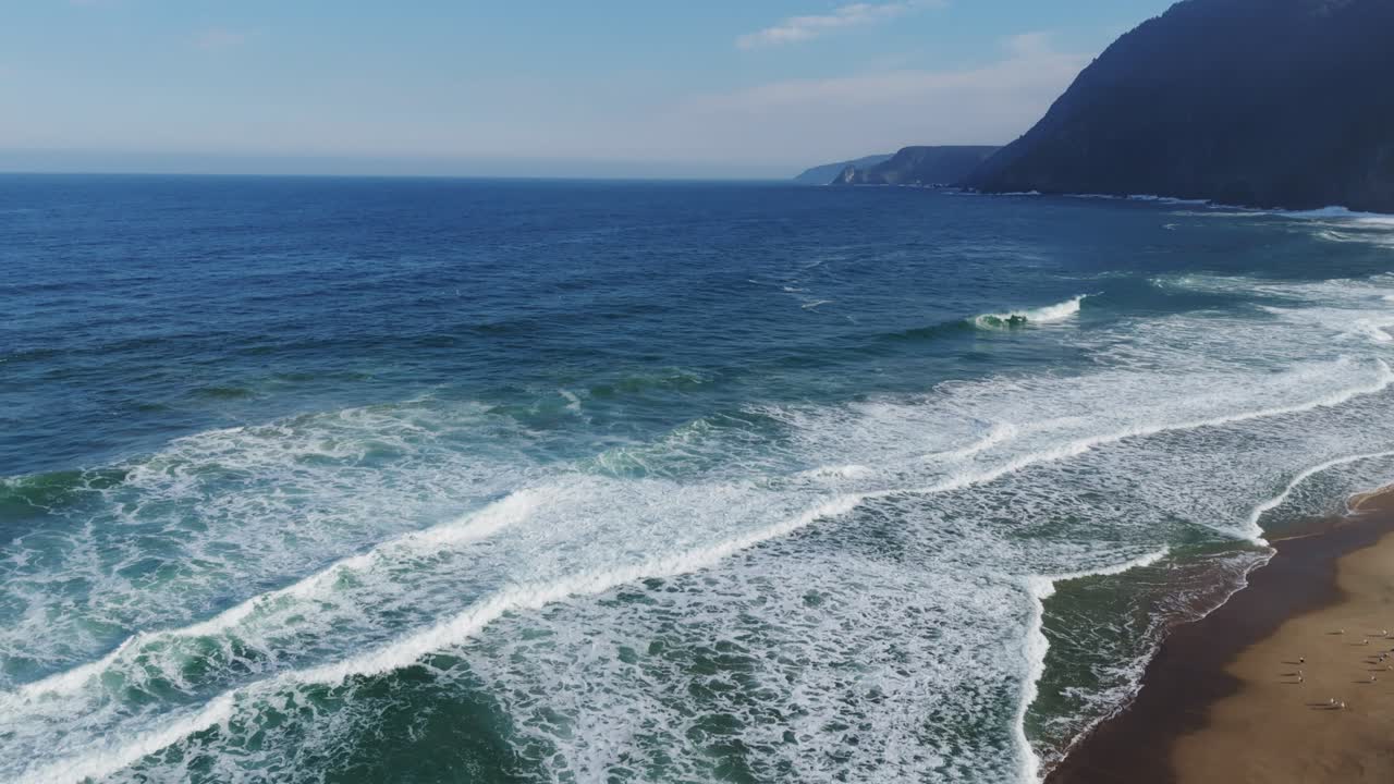 Aerial view of Playa Grande showing waves crashing on the coastline in Quintay, Chile. Rising Shot