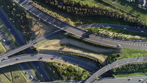 perspectiva aérea estática mirando directamente hacia abajo mientras el tráfico se mueve a lo largo de la intersección de la carretera hacia su destino