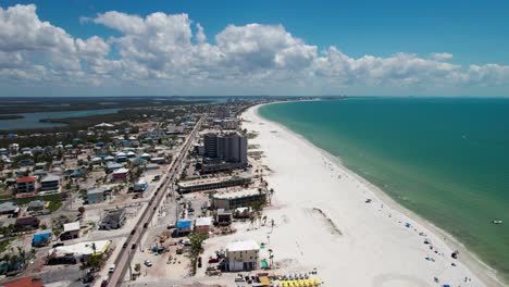 drone shot flying over businesses on the beach in fort myers beach