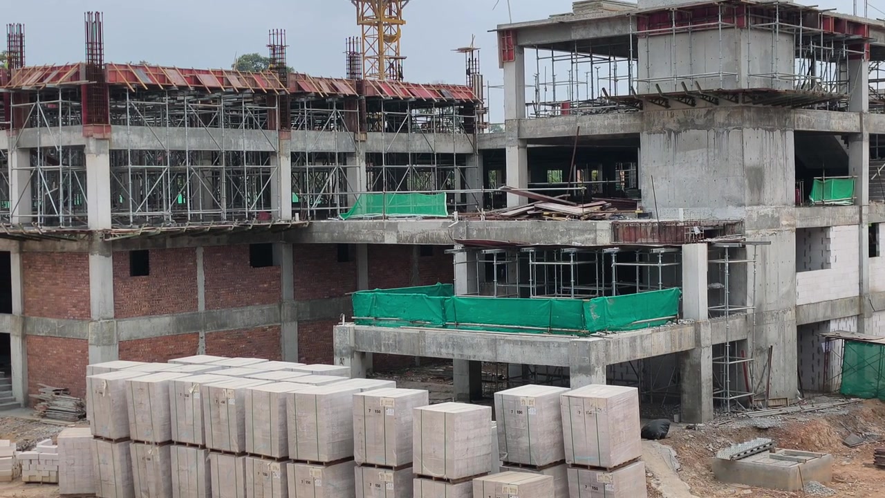 Construcción activa de un edificio de gran altura en curso. Se aplican estrictas medidas de seguridad en el lugar. Los materiales pesados están organizados de forma ordenada para un flujo de trabajo eficiente.
