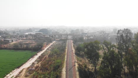 Vehicles-crossing-on-the-bridge-over-the-railway-track-near-the-fields-in-Punjab