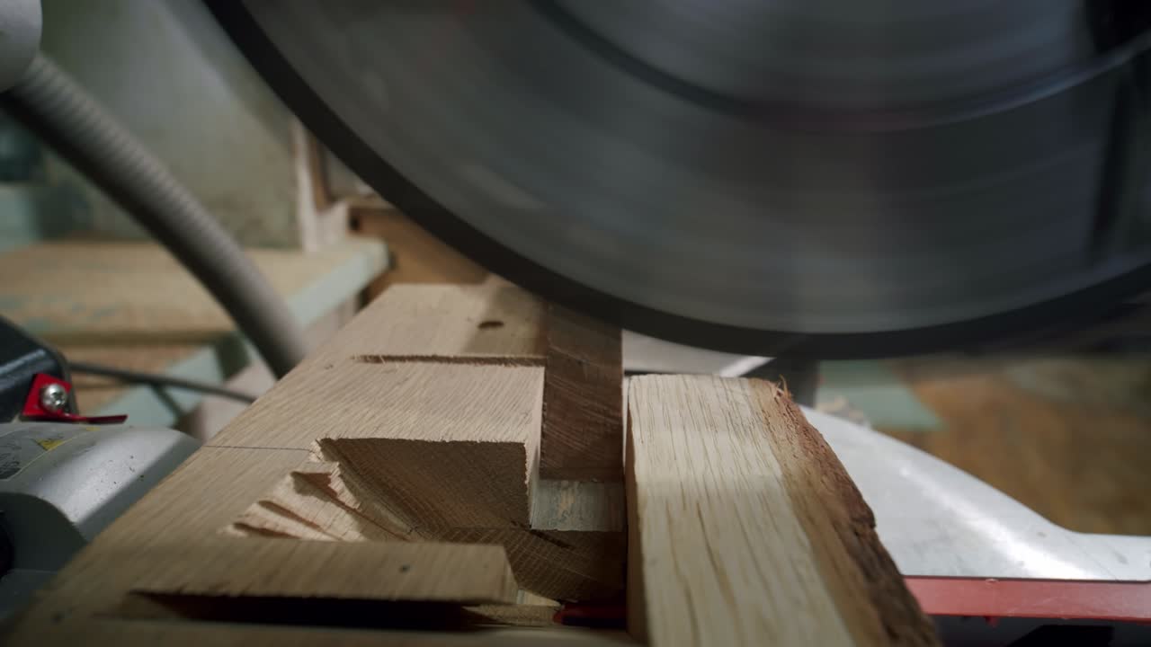 de cerca. el maestro corta una tabla de madera con una sierra circular en el taller de carpintería de un pequeño fabricante de muebles. cámara lenta
