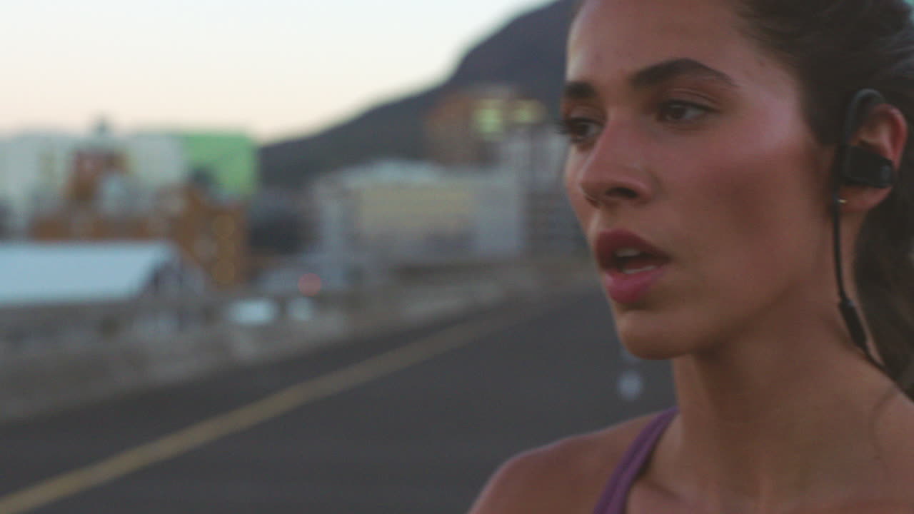 mujer corriendo por la ciudad al atardecer