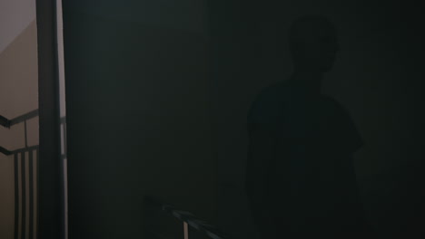 a bald man walks on the empty hospital staircase at night