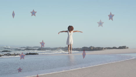 animation of stars over african american woman raising hands at beach