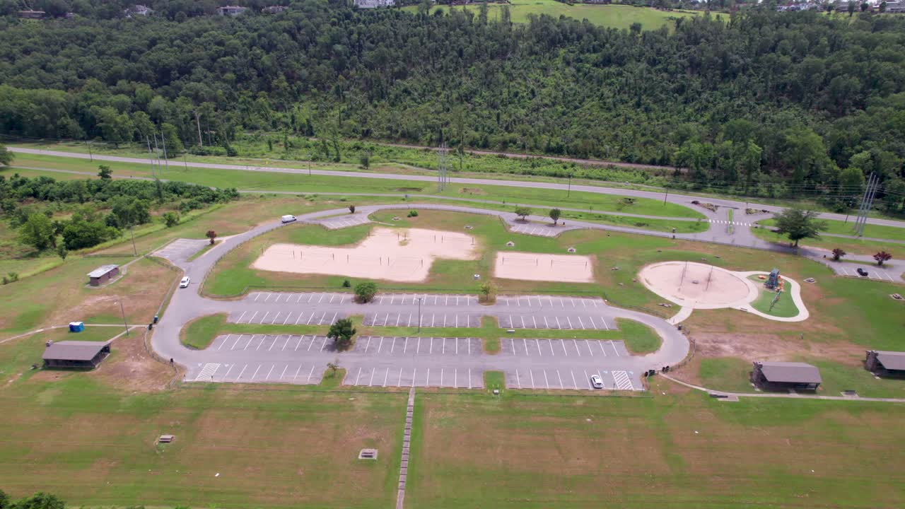 Aerial footage of Murray Park in Little Rock Arkansas. Camera flies over a parking lot and you can see sand volleyball courts