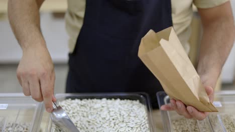 person putting beans inside paper bag